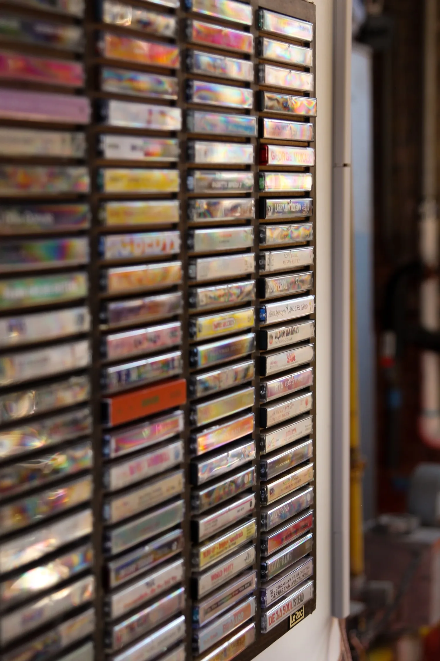 A wooden wall rack holding several hundred cassette tapes
