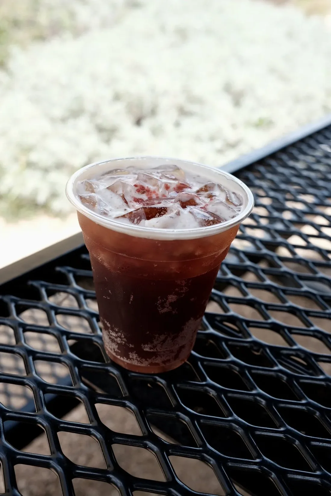 Strawberry hibiscus fizz over ice on a patio table